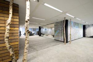 Modern office interior with natural wooden elements and a large map of Amsterdam on the wall.